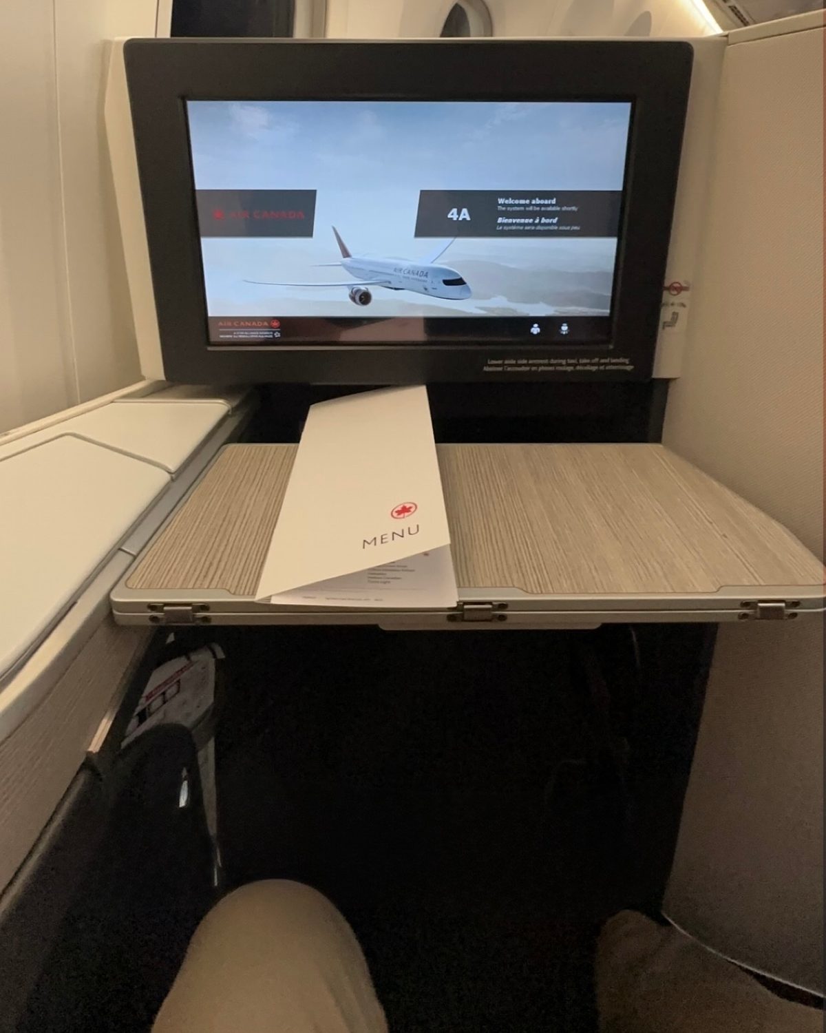 An Air Canada business-class seat 4A set up for dinner service