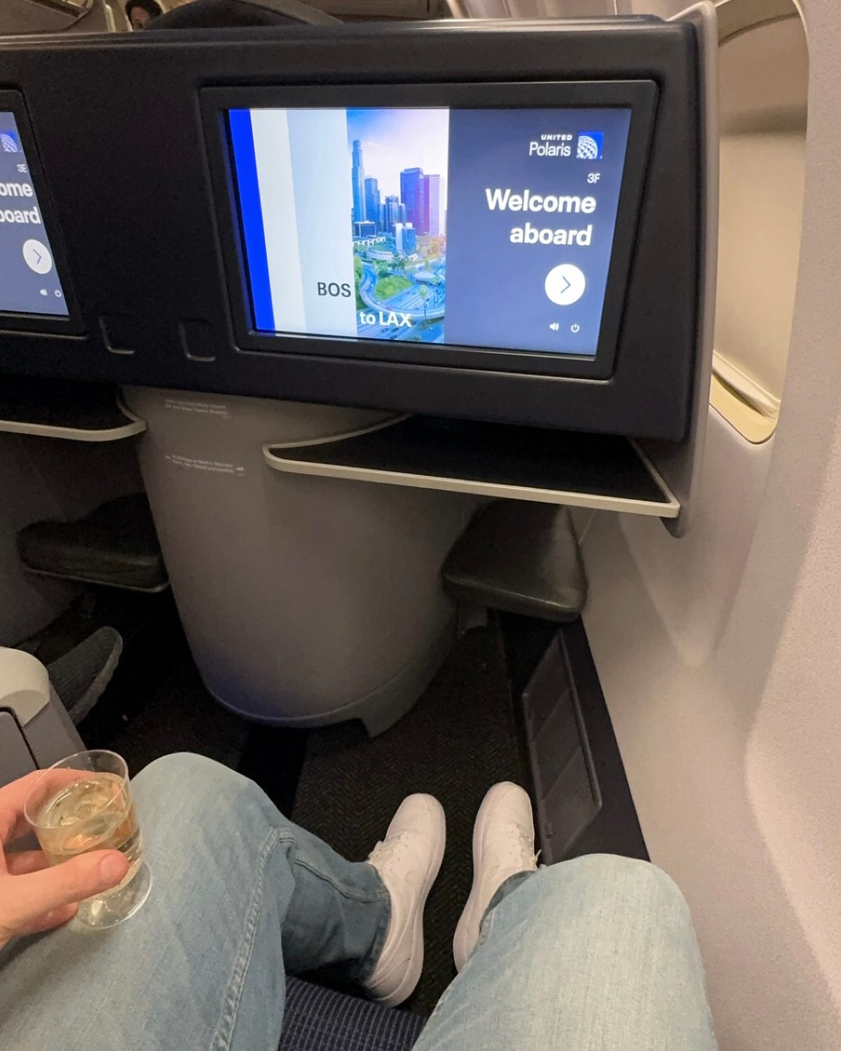 A United Polaris business-class seat screen showing a Boston to Los Angeles route