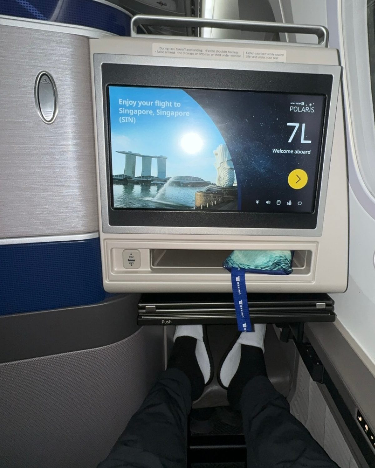 A United Polaris business-class seat screen showing arrival into Singapore